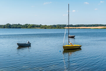 Three small boats in the lake or river on a sunny day