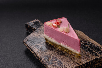 Piece of sweet cheesecake with pink cream cheese of raspberry or strawberry flavor