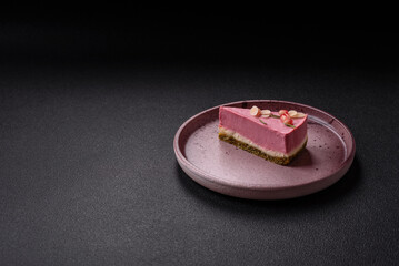 Piece of sweet cheesecake with pink cream cheese of raspberry or strawberry flavor