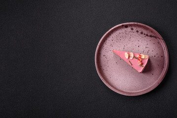 Piece of sweet cheesecake with pink cream cheese of raspberry or strawberry flavor