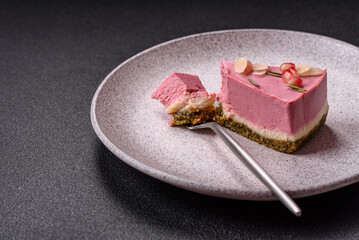 Piece of sweet cheesecake with pink cream cheese of raspberry or strawberry flavor