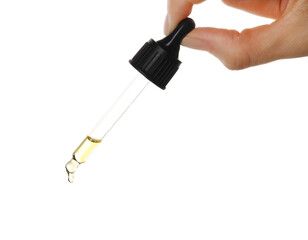 Essential oil dripping from pipette against white background