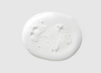 Close-up of white liquid soap with bubbles on gray background reflecting cleanliness and minimalist beauty concepts