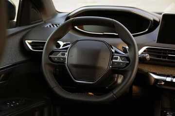 Steering wheel and dashboard inside of modern luxury car, closeup