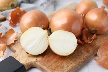 Fresh onions with peels on table, closeup