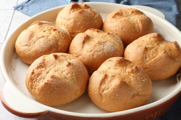 Baking dish with homemade tasty buns on table, closeup