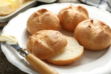 Plate with homemade tasty buns, butter and knife on table, closeup
