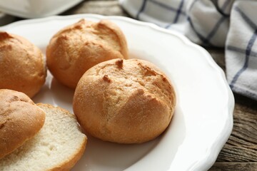 Plate with homemade tasty buns on wooden table, closeup