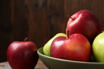 Fresh red and green apples on wooden table, closeup