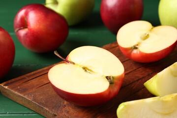 Fresh ripe apples on green wooden table, closeup