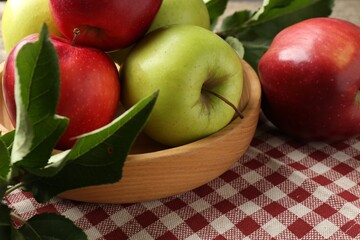 Ripe apples and green leaves on table, closeup