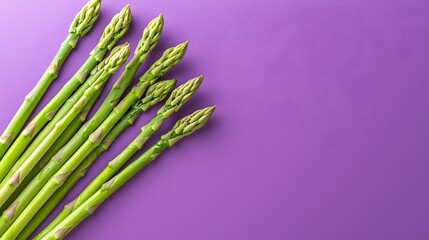 Naklejka premium Vibrant Diagonal Asparagus Spears on Rich Purple Background - Fresh and Colorful Vegetable Arrangement for Culinary and Food Photography