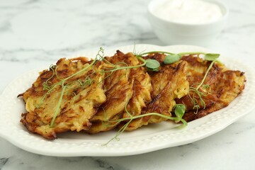 Delicious potato pancakes with fresh microgreens on white marble table, closeup