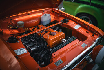 Fototapeta premium Open bonnet of a classic car displaying fully restored engine compartment.
