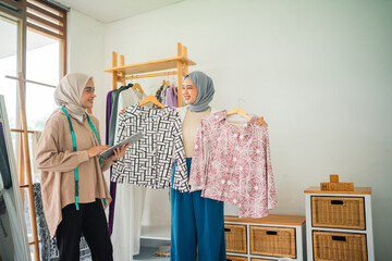 In a bright boutique, two women explore various stylish clothing options together