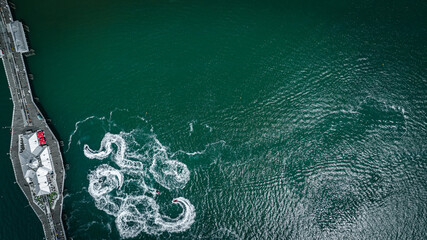 Aerial view of jet ski arount Brighton pier on a sunny summer day, East Sussex, UK