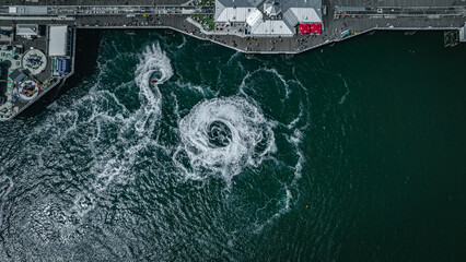 Aerial view of jet ski arount Brighton pier on a sunny summer day, East Sussex, UK
