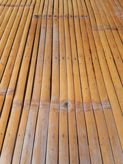 Dry bamboo background. Close up wood planks texture. Perspective view of thin brown bamboo slats. Bamboo cane cladding.