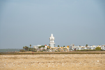 sand beach at Isla Christina at the Costa de la Luz in Andalusia with view to town and lighthouse