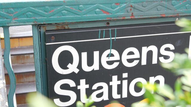 New York subway sign, Queens underground metro station. Metropolitan entrance fence, public transport exit. Long Island city street, NYC United States. Navigation text on signboard. Passenger guidance