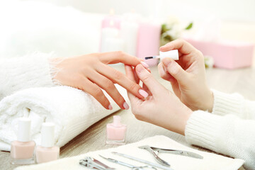 Manicurist making manicure for client in salon