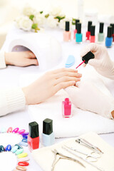 Manicurist making manicure for client in salon