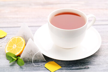 Cup of tea with lemon and mint leafs on wooden table