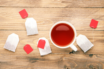 Cup of tea with tea bags on brown wooden table