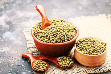 Soy beans with bowls and spoons on grey background