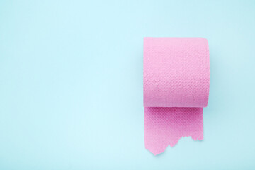 Pink roll of toilet paper on blue background