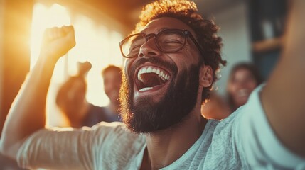 Ecstatic man wearing glasses cheers energetically, surrounded by friends, emphasizing happiness, success, and the joy of shared moments in social settings.