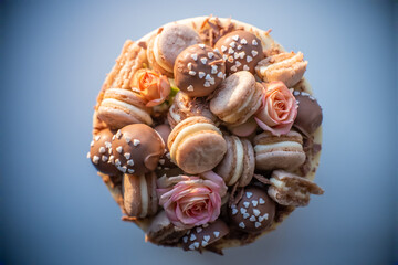Yummy birthday cake adorned with macarons and chocolate balls awaits the arrival of guests for a celebration