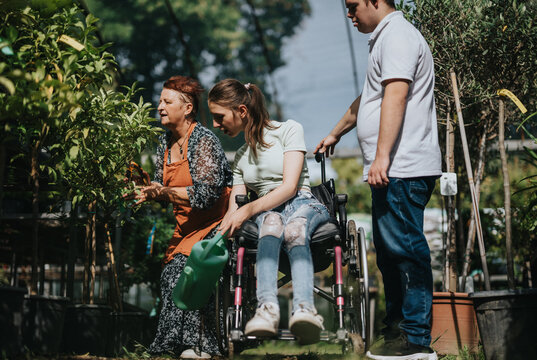 An elderly woman, a girl in a wheelchair, and a boy with Down syndrome enjoy gardening together. The image captures community, diversity, and inclusion in an outdoor setting.