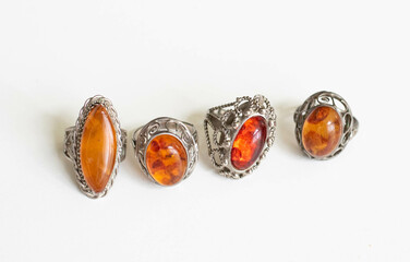 Collection of Vintage Amber Stone Rings – Flatlay on White Background with Soft Lighting