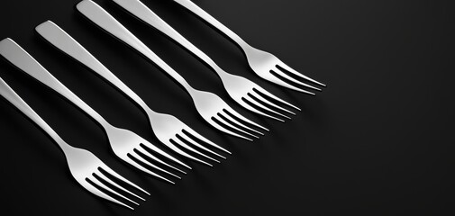 Naklejka premium Elegant row of shiny forks, perfectly aligned on a black surface, showcasing sleek and modern cutlery design