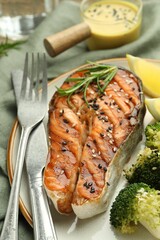 Tasty grilled salmon steak with broccoli served on table, closeup