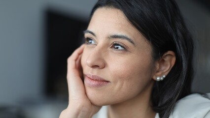 Businesswoman holding chin, thinking and looking up with hope