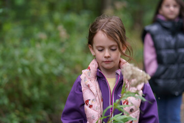 A cute little girl  walks through a dense forest with her mother. Happy family concept
