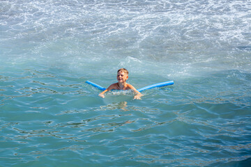 Cute boy with snorkeling equipment at tropical beach enjoying summer vacation