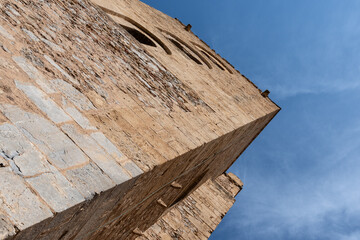 view from below of the ancient towers of the Norman cathedral of Cefal&ugrave; in Sicily silhouetted majestically against an incredibly blue sky
