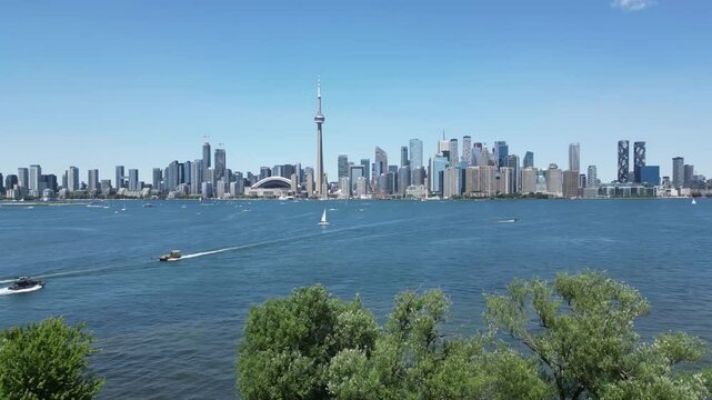 Aerial view of downtown Toronto skyline view flying slowly forward showing the entire city shoreline including the famous CN tower boats, ferries and water taxis