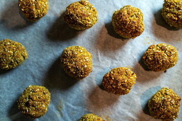 A close-up of freshly baked falafel balls on parchment paper, showcasing a delicious homemade vegan and vegetarian snack option. Perfect for healthy meals and appetizing food presentations.