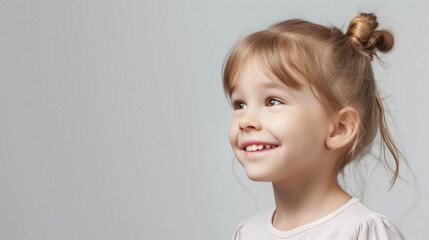 Concept for dentistry: a six-year-old blonde girl smiles, revealing her healthy white teeth on a blue background. Text space provided.