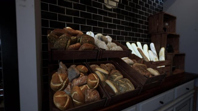 A display case filled with a wide variety of bread types arranged on store shelves.