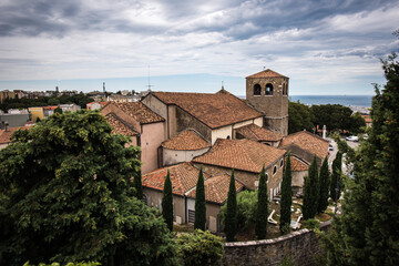Fototapeta premium The Cattedrale di San Giusto in Trieste, Italy, is beautifully captured from the top of the Civico Museo del Castello di San Giusto, showcasing its Romanesque architecture and historic charm.