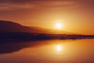 Sunset over lake in summer, vibrant dramatic colors
