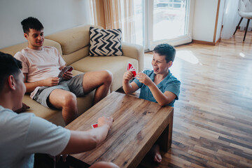 Older teenagers playing a card game with their younger brother in a cozy living room