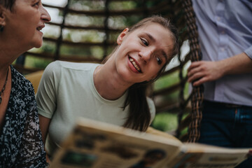 A joyful young girl with a disability shares a heartwarming moment reading with friends in a cozy...