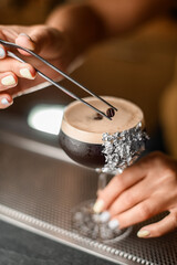 Close-up shot of a tall stemmed glass with a cold foamy coffee drink