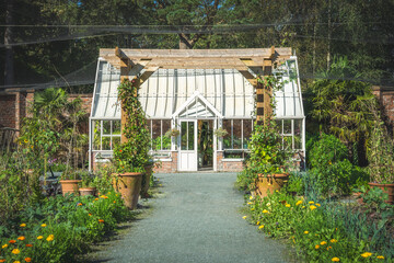A Victorian style greenhouse in a formal walled garden on an English estate